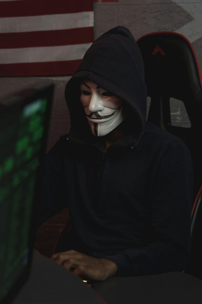 Express VPN Review Security. This image portrays a man with a mask doing some anonymous work on the internet.. It emphasizes that Express VPN will keep you safe on the internet. 