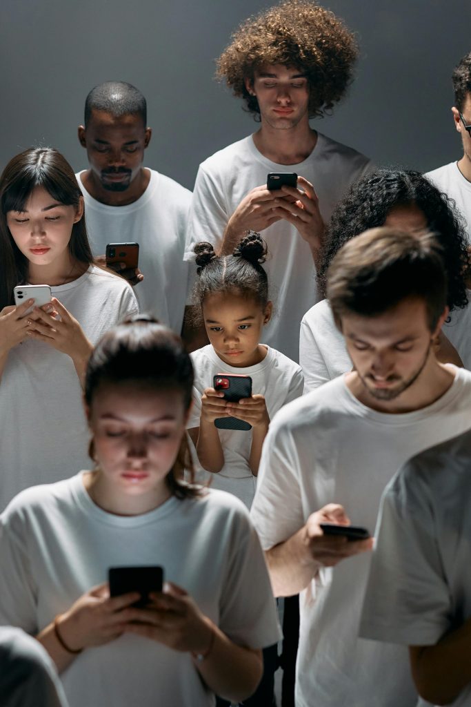 Express VPN Review. This image features a few people standing with their phones in hand busy texting or watching something. 